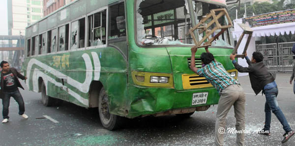 DEC 10 2012-Dhak, Bangladesh- the Pro-hartal activists vandalize a bas at Kakrail area in Dhaka on Monday. The activists of BNP and its close ally Jamaat-e-Islami set fire to at least nine buses and vandalized many others in the capital on the eve of Tuesday's dawn-to-dusk nationwide strike. They are demanding restoration of the caretaker government system. © Monirul Alam